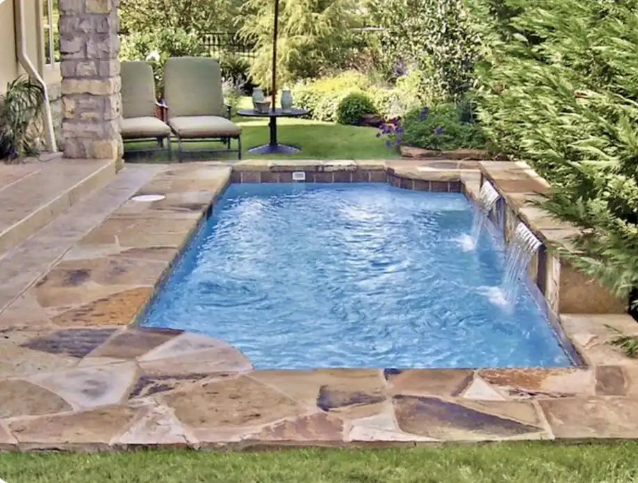 Flagstone-coped pool with three sheer-descent waterfalls spilling from a stone ledge